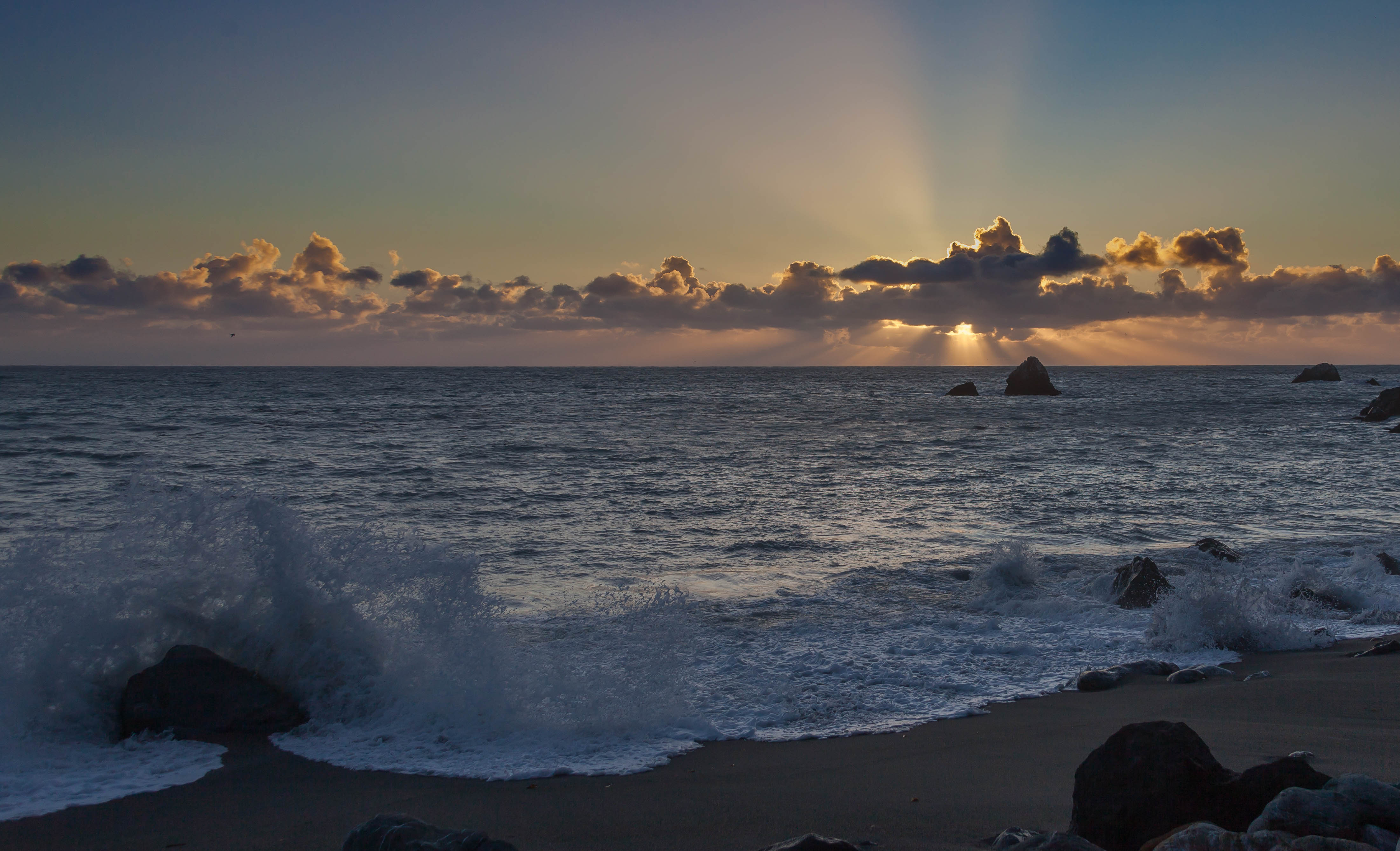 Sunset at Limekiln State Park, with a wave crashing on a rock